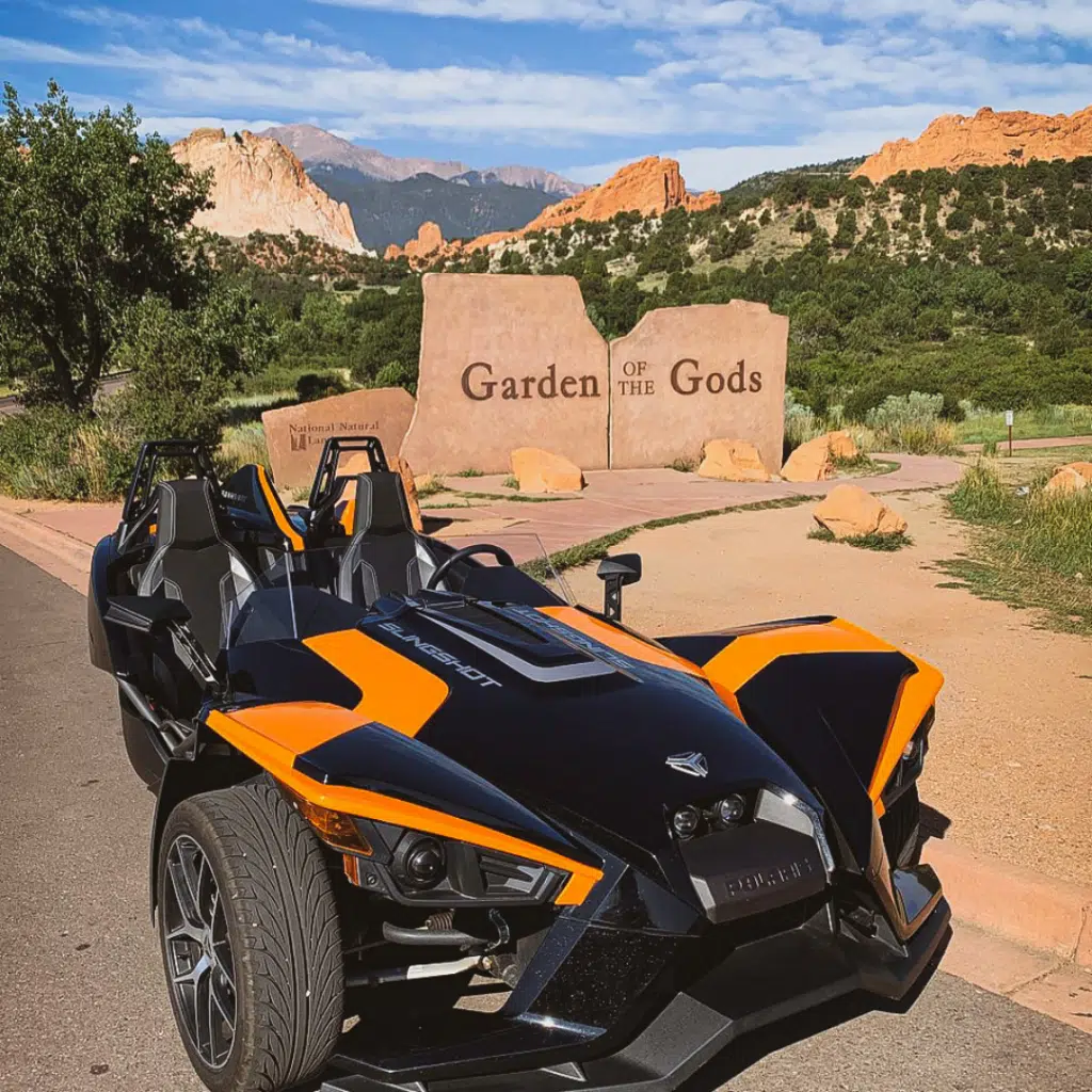 orange slingshot parked in front of the Garden of the Gods sign