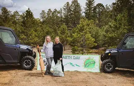 Two women cleaning holding trash bags on Earth day, Great Outdoor Adventures