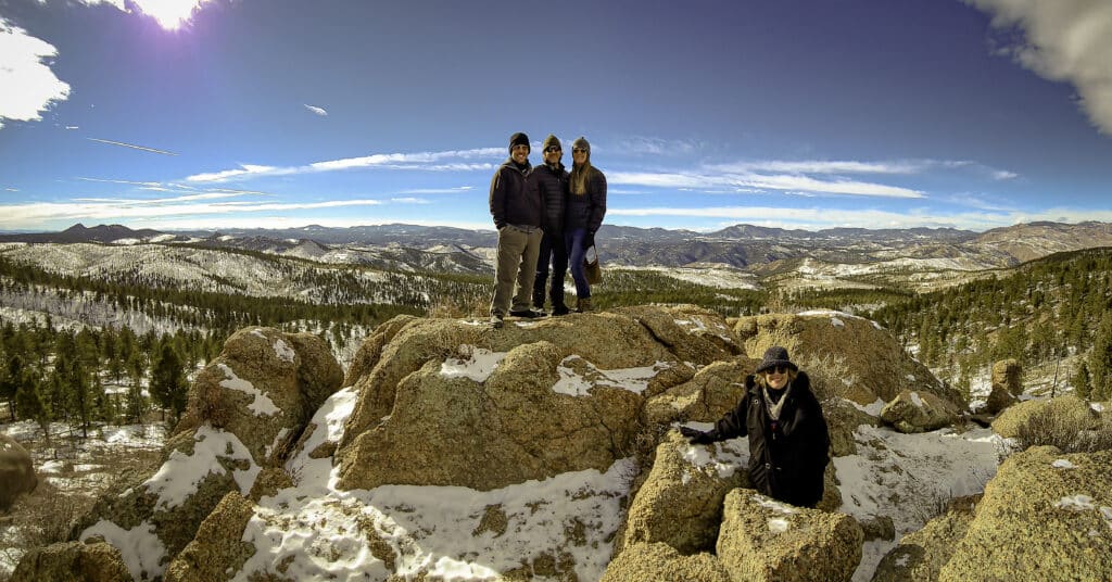 Grupo de personas disfrutando de actividades invernales cerca de Woodland Park, Colorado, con montañas cubiertas de nieve al fondo, mostrando aventuras en UTV y Jeep con Great Outdoors Adventures.