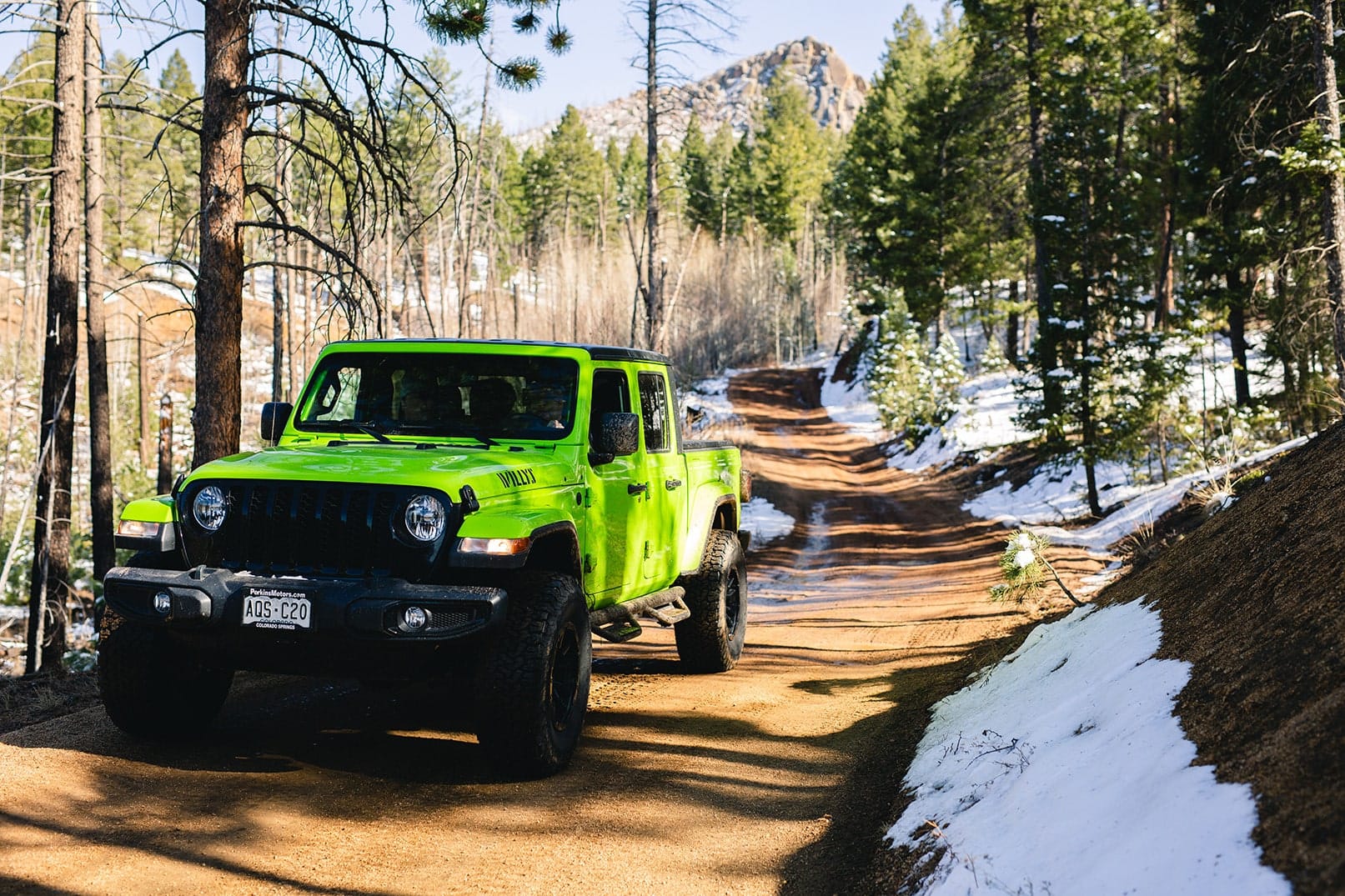 Jeep Gladiator rental on a backcountry dirt road in Colorado, perfect for off-road adventure and scenic Rocky Mountains exploration.
