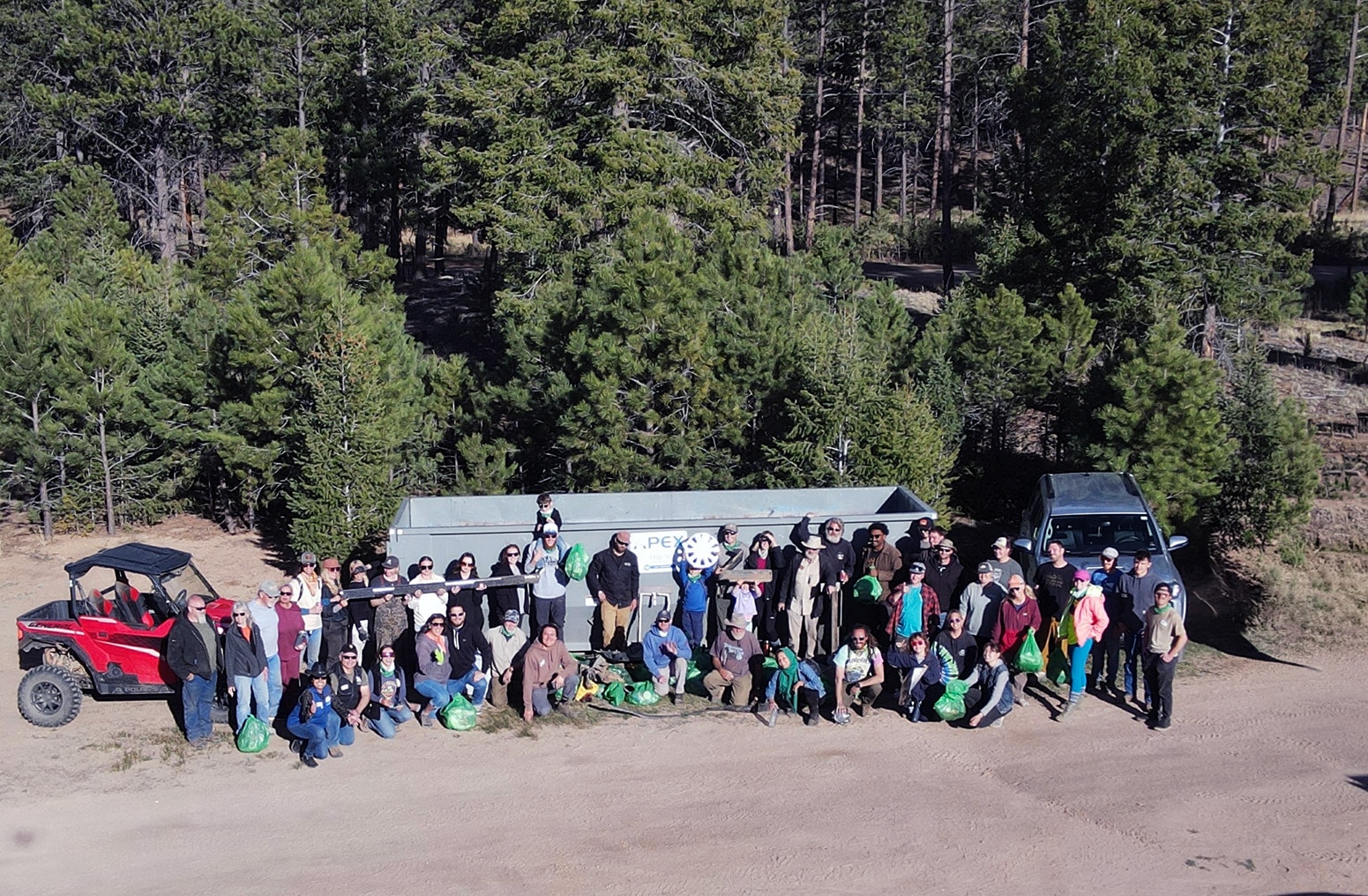 A group of nearly 50 volunteers and community partners standing together in the Pike National Forest for the Great Outdoors Adventures Earth Day trail cleanup.